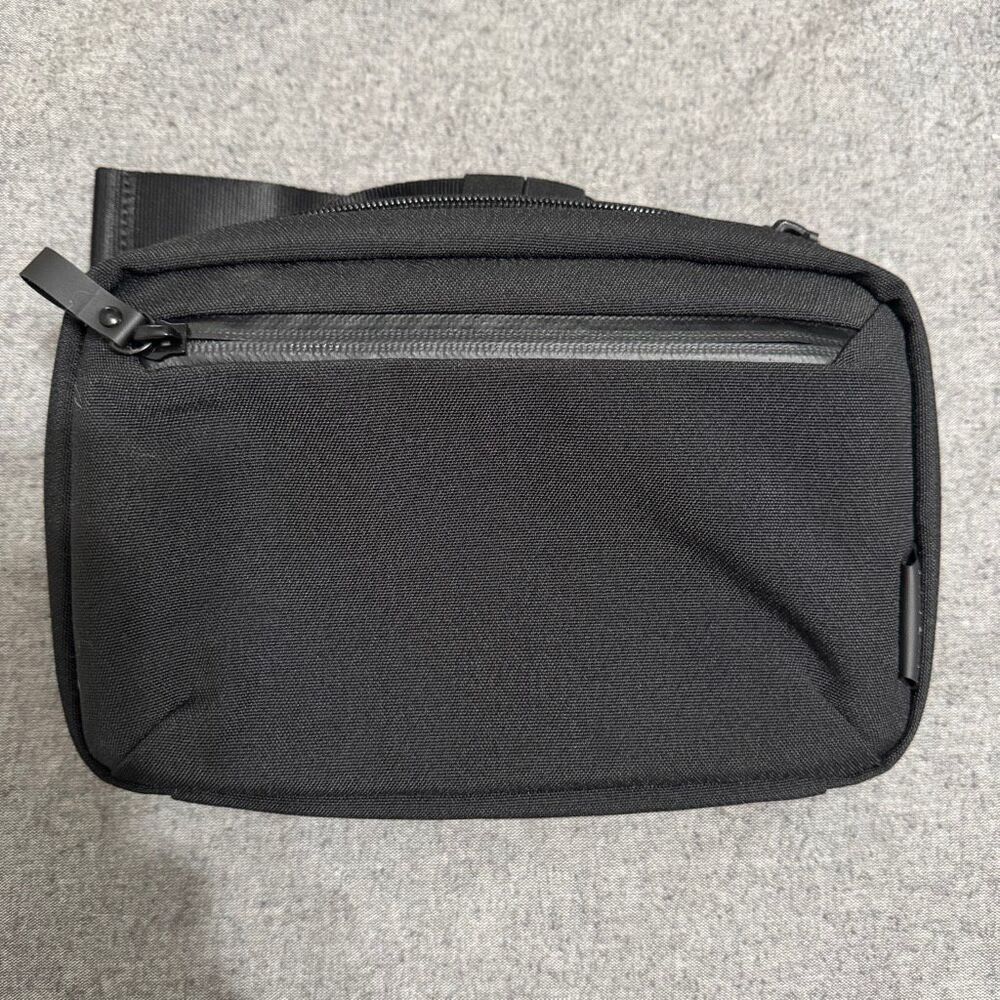 Alpaka black sling bag with front pocket and fidlock buckle